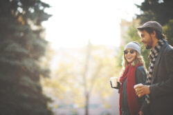 Couple standing outside drinking coffee