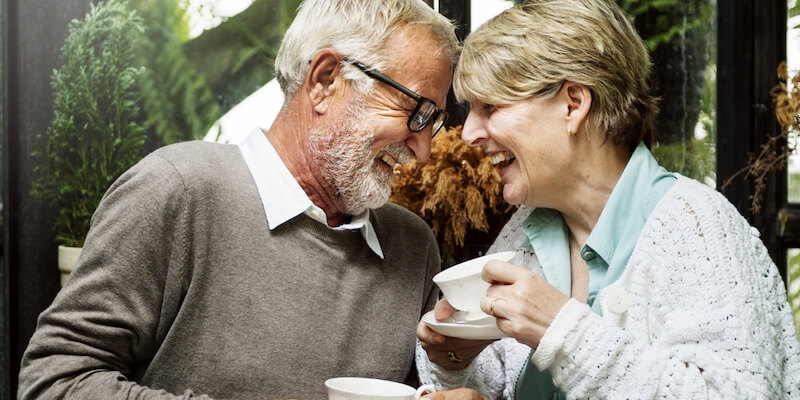 Older couple laughing and drinking tea
